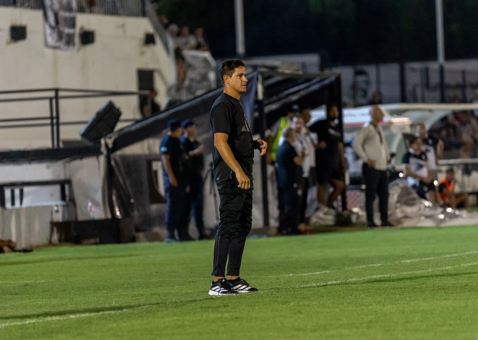 Trainer steht an der Seitenlinie eines Abendspiels